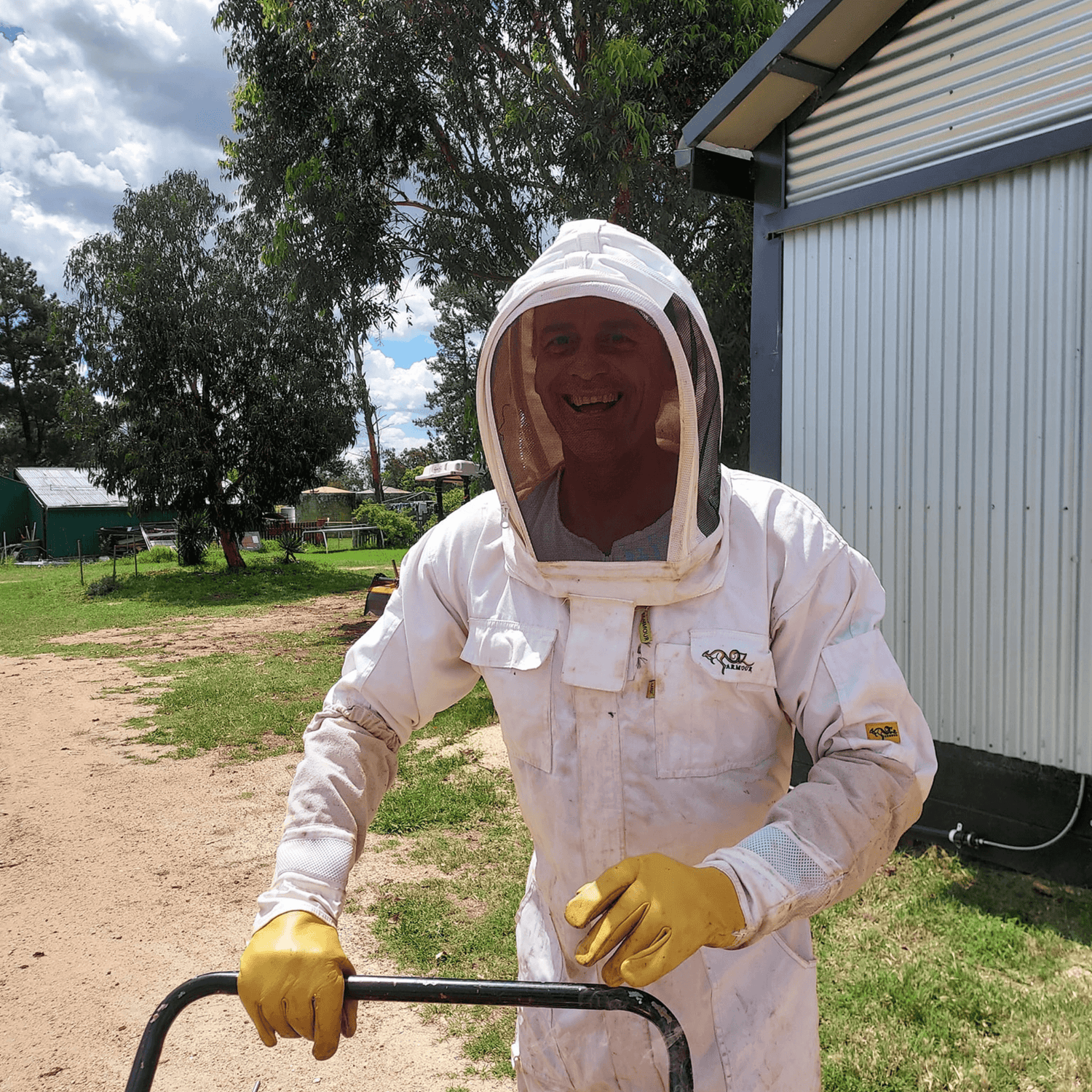 School holiday activities family farm experience with beekeeper in protective suit teaching kids about bees