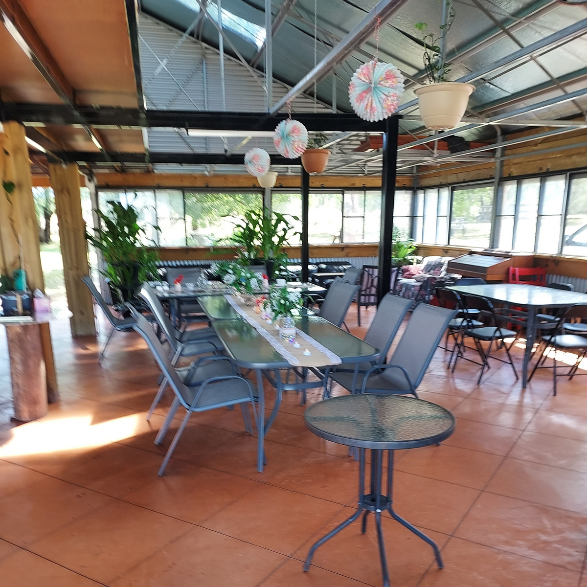 Indoor seating area at Evergrow Farm Hub Café with modern rustic décor and large tables for group bookings.