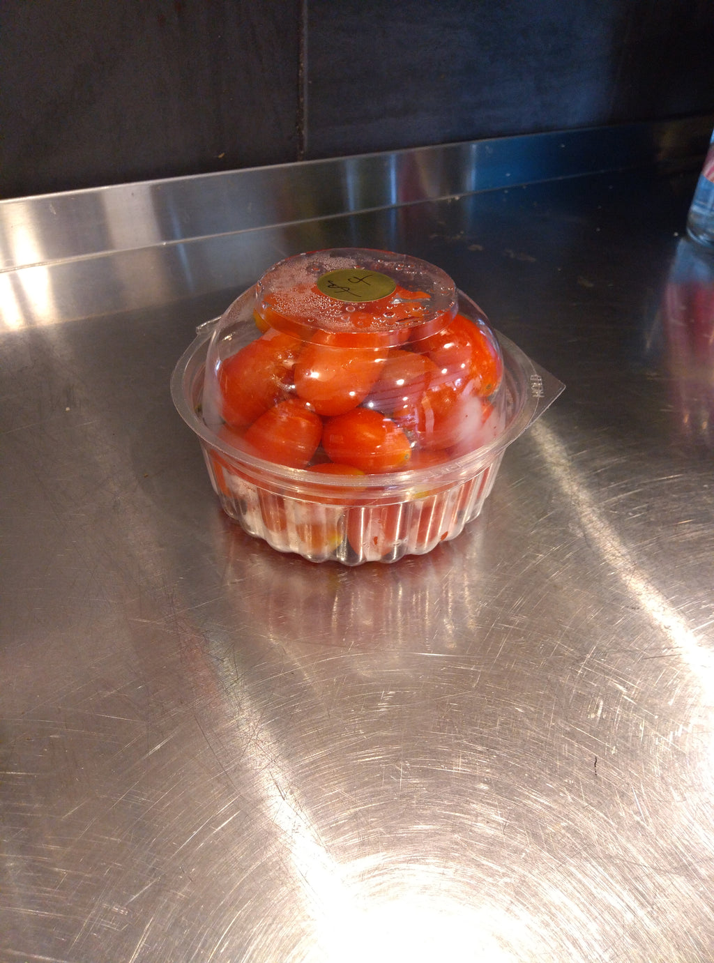 Clear plastic container with cherry tomatoes in a 250g takeaway.