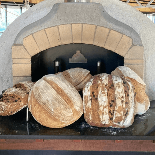 Freshly baked artisan bread loaves cooling in a traditional stone oven